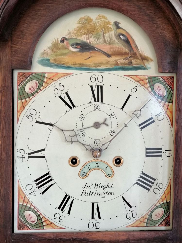 Image of clock face with roman numerals and fanciful birds above.