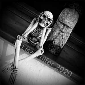 Black and white image of a skeleton ornament and a Green Man carving.