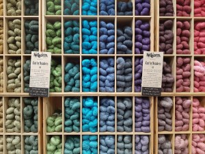 A wall display of coloured yarns.